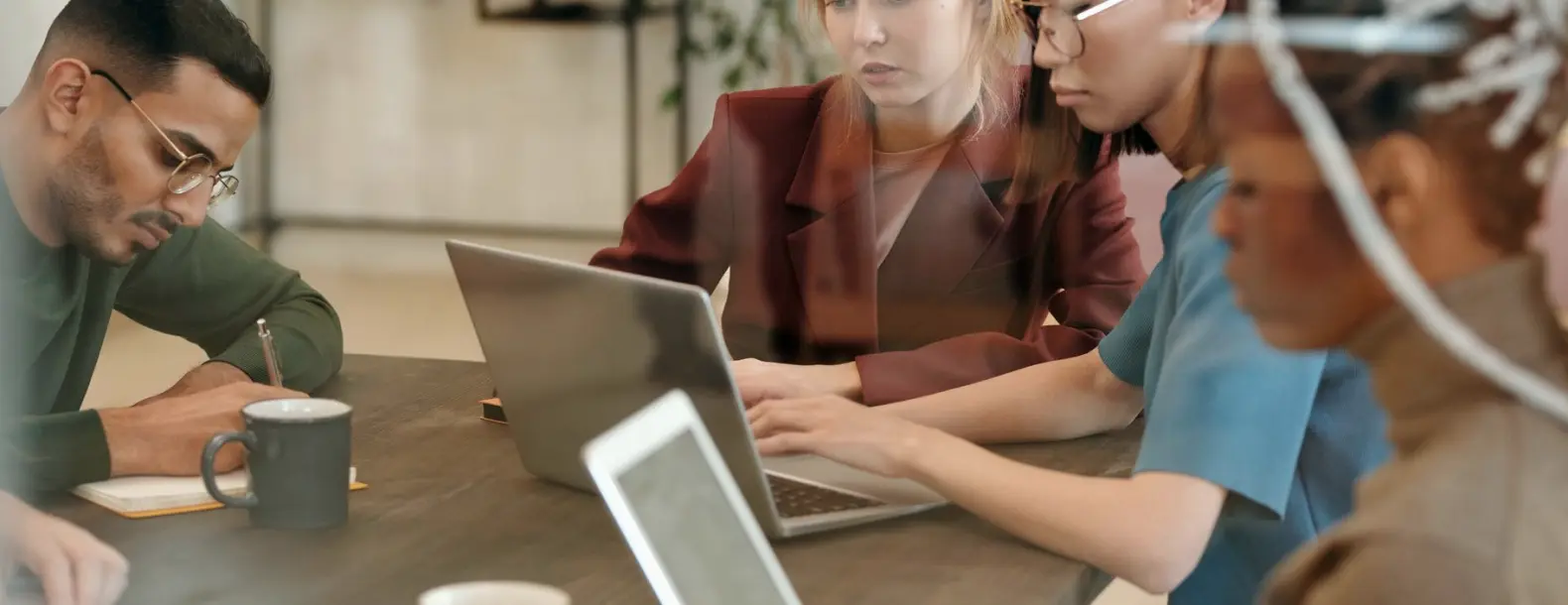Et arbejdsbord med noter, diagram og skærm midt i et redaktionelt forløb